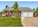 Traditional home featuring a well-manicured lawn, brick facade, and a two-car garage at 5456 E Briarwood Pl, Centennial, CO 80122