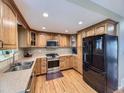 Well-lit kitchen featuring wooden cabinets, stainless steel appliances, and hardwood floors at 5456 E Briarwood Pl, Centennial, CO 80122
