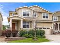 Two-story home with a well-kept lawn, stone accents, covered porch, and attached two-car garage at 19722 W 59Th Ave, Golden, CO 80403