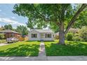Well-maintained single-story home with a large tree in the front yard at 740 Cherry St, Denver, CO 80220