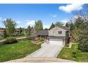 Attractive two-story home with a well-kept lawn, mature trees, and a long driveway leading to the garage at 10743 W Turtle Mtn, Littleton, CO 80127