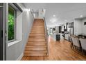 Bright entryway featuring a staircase, hardwood floors, and an open layout with sight lines to the kitchen at 2523 N Humboldt St, Denver, CO 80205