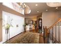 Grand foyer with soaring ceilings, hardwood floors, elegant chandelier, and staircase leading to the upper level at 9188 Buck Hill Dr, Highlands Ranch, CO 80126