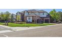 Street view of an elegant brick home with manicured lawn and a three car garage at 9188 Buck Hill Dr, Highlands Ranch, CO 80126