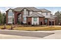 Lovely brick and white home with a well-manicured lawn and inviting brick walkway up to the front entrance at 9188 Buck Hill Dr, Highlands Ranch, CO 80126