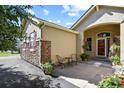 Charming front entrance with a covered porch, stone accents, tasteful landscaping, and a decorative front door at 42340 Kingsmill Cir, Elizabeth, CO 80107