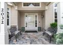 Welcoming front porch with seating area, stone flooring, and elegant front door at 2032 W Nantucket Ct, Littleton, CO 80120