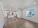 Open-concept living room with wood floors and bright natural light at 10689 Uravan St, Commerce City, CO 80022