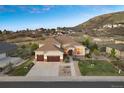 Aerial view of a tan two-story home with a three-car garage situated on a picturesque lot at 223 Castlemaine Ct, Castle Rock, CO 80104