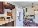 Kitchen featuring a white refrigerator, microwave, and adjacent dining area at 18891 E Carmel Dr, Aurora, CO 80011