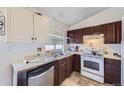 Kitchen featuring a stainless steel dishwasher, and white appliances with dark brown cabinets at 18891 E Carmel Dr, Aurora, CO 80011
