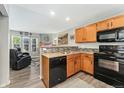 Kitchen featuring granite countertops, wooden cabinets, and modern appliances open to cozy living room area at 3090 W 107Th Pl # F, Westminster, CO 80031