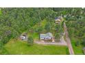 Charming home with lush green lawn and a surrounding forest at 4724 Hopi Rd, Indian Hills, CO 80454