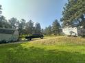 Beautiful property featuring a long driveway, lush green lawn, mature trees, and ample parking at 4724 Hopi Rd, Indian Hills, CO 80454