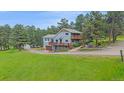 Two-story home with a large yard, multiple decks, and attached garage at 4724 Hopi Rd, Indian Hills, CO 80454