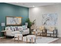 Living area features neutral decor, decorative pillows, and plush seating, accented by the teal accent wall at 3384 Cranston Cir, Highlands Ranch, CO 80126