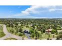 Wide aerial view of a charming home nestled among mature trees and green spaces in a quiet community at 5542 Ponderosa Dr, Parker, CO 80134