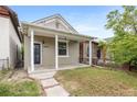 Exterior showcasing its covered porch, neutral colors, and charming front yard at 2841 Stout St, Denver, CO 80205