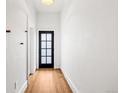 View of a hallway featuring hardwood floors and a glass panel front door at 2841 Stout St, Denver, CO 80205
