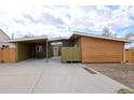 Modern home featuring wooden siding, a carport, and a well-kept concrete driveway and green grass at 5350 E 66Th Way, Commerce City, CO 80022