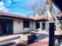 Backyard patio featuring a unique brick firepit, stucco walls, and sliding glass doors at 7194 S Himalaya Way, Centennial, CO 80016