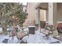 Small patio with seating area and fire pit covered in snow at 12460 S Hollow Creek Ct, Parker, CO 80134