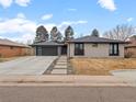 Charming single-story home featuring a modern garage door, inviting walkway, and updated exterior paint at 3049 S Vine St, Denver, CO 80210