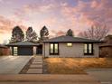 Charming single story brick home features a modern garage, pathway and manicured front yard under a colorful sky at 3049 S Vine St, Denver, CO 80210