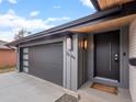 Close up of modern front door and garage with unique address display and stylish exterior lighting at 3049 S Vine St, Denver, CO 80210
