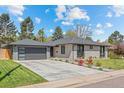 Beautiful exterior with a manicured lawn, mature trees, and concrete driveway at 3049 S Vine St, Denver, CO 80210