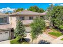 Charming two-story home featuring a well-maintained lawn, a two-car garage, and mature trees at 13895 Sandtrap Cir, Broomfield, CO 80023