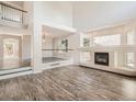 Open living room featuring wood floors, a fireplace, large windows, and high ceilings at 13895 Sandtrap Cir, Broomfield, CO 80023
