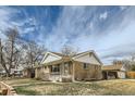 Well-kept single-Gathering home featuring a brick exterior, cozy front porch, and neat landscaping at 283 Garland Dr, Northglenn, CO 80233