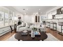 Bright and airy living room with hardwood floors, modern furnishings, and seamless flow to the dining area at 403 S Niagara St, Denver, CO 80224