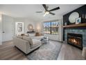 Bright living room featuring a corner fireplace, large window, and comfortable seating at 5250 Cody St, Arvada, CO 80002