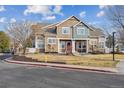 Two-story townhome featuring stone accents, a red front door, and a well-maintained front lawn at 13271 Holly St # D, Thornton, CO 80241