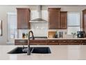 Modern kitchen with quartz countertops, dark cabinetry, stainless steel appliances, and tile backsplash at 18926 W 93Rd Ave, Arvada, CO 80007