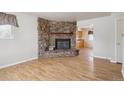 Inviting living room featuring a stone fireplace and gleaming hardwood floors at 4591 S Pennsylvania St, Englewood, CO 80113