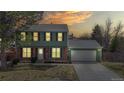 Charming two-story home exterior view at dusk, showcasing inviting curb appeal with warm interior lighting at 12426 W Temple Dr, Morrison, CO 80465