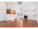 Bright living room featuring hardwood floors, a fireplace, and staircase to the upper level at 2430 S Halifax Way, Aurora, CO 80013