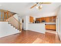 Open-concept living space with hardwood flooring and a staircase leading to the upper level at 2430 S Halifax Way, Aurora, CO 80013