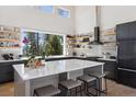 Contemporary kitchen with a large island, sleek appliances, and expansive windows overlooking the lush greenery at 2536 N State Highway 67, Sedalia, CO 80135