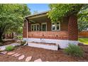 Charming brick home featuring a cozy front porch and lush landscaping, adding curb appeal at 3321 Stuart St, Denver, CO 80212