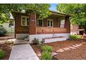 Charming brick home showcasing a welcoming front porch and beautifully landscaped yard at 3321 Stuart St, Denver, CO 80212