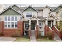 Two-story townhome featuring brick accents, green siding, and a charming front entrance at 9852 E Idaho St, Aurora, CO 80247