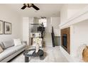 Inviting living room with cozy fireplace, staircase, and comfortable seating arrangement at 9852 E Idaho St, Aurora, CO 80247