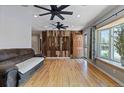 Spacious living room with wood floors, modern ceiling fans, and a decorative wood accent wall at 4102 W Eastman Ave, Denver, CO 80236