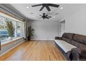 Spacious living room filled with natural light, hardwood floors, ceiling fans, and a comfortable leather couch at 4102 W Eastman Ave, Denver, CO 80236