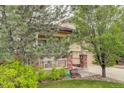 A charming two-story home with a brick-accented porch and mature landscaping at 15372 E 117Th Ave, Commerce City, CO 80022