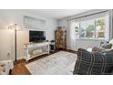 Cozy living room with a large window, modern decor, and a plush rug over hardwood floors at 4502 S Gar Way, Littleton, CO 80123